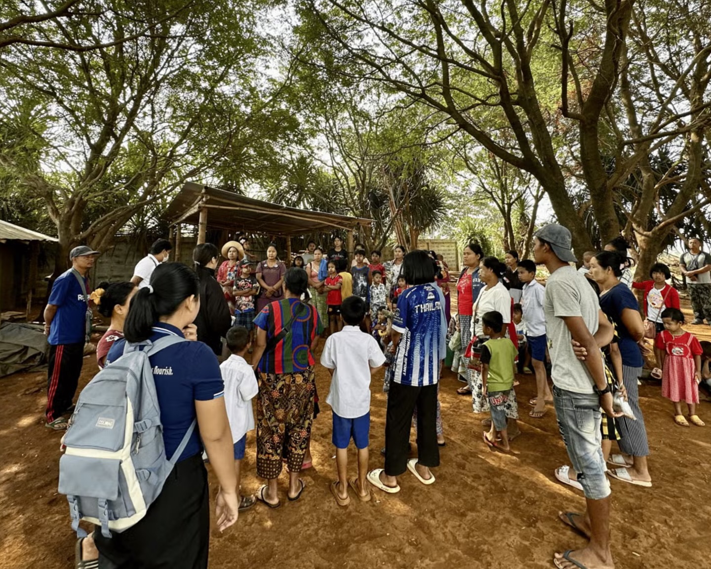 The workshop participants gathered outside beneath the trees.