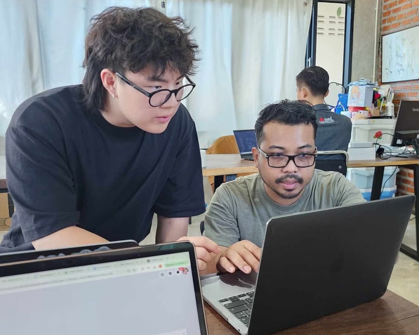 The co-op workshop team working together at the laptop in Thailand.