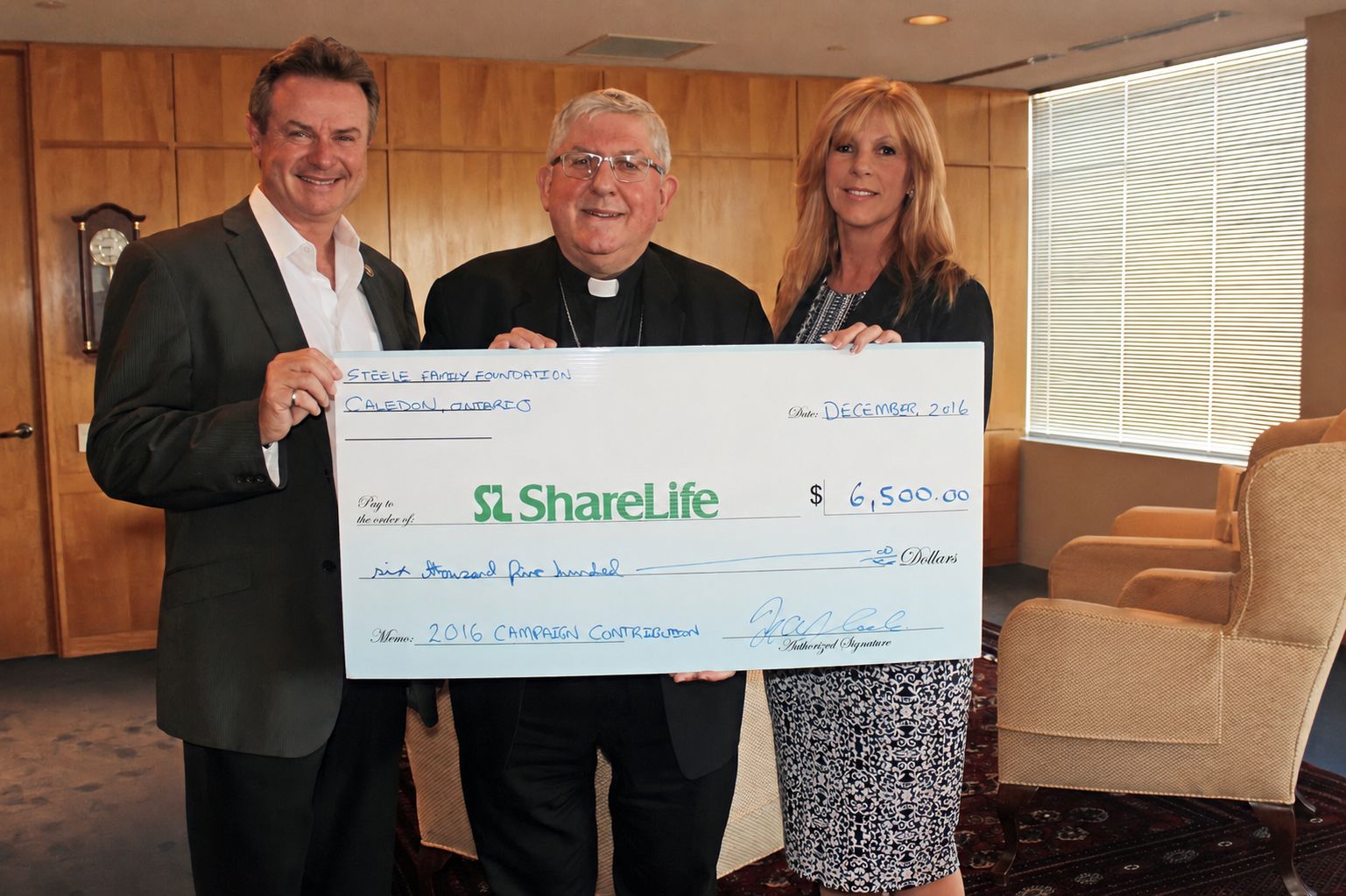 Three people holding a Steele Family Foundation cheque in support of ShareLife’s 2016 campaign.